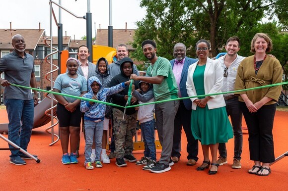 Mayor Scott cutting ribbon at Solo Gibbs Park with children and other people around him